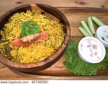Rice Lamb Biryani Pilaf With Lamb Or Mutton Meat And Vegetables Cucumber Along With Yoghurt In A Ver