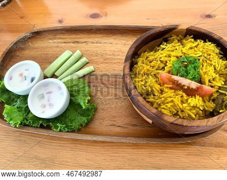 Rice Lamb Biryani Pilaf With Lamb Or Mutton Meat And Vegetables Cucumber Along With Yoghurt In A Ver