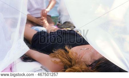 Male Masseur Massages The Legs In A Beautiful White Ornamrental Tent.