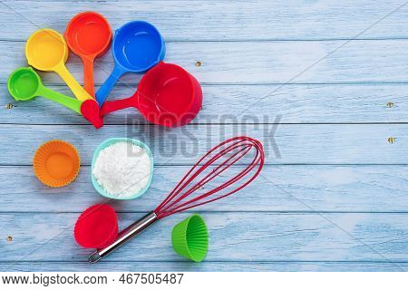 Top View Set Of Kitchen Utensils And Ingredients For Bakery On Blue Wooden Floor. Materials Or Kitch