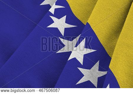Bosnia And Herzegovina Flag With Big Folds Waving Close Up Under The Studio Light Indoors. The Offic