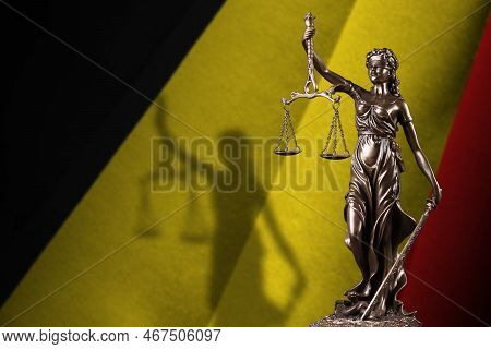 Belgium Flag With Statue Of Lady Justice And Judicial Scales In Dark Room. Concept Of Judgement And 