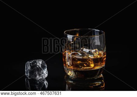 Whiskey With Ice In Glass On Dark Background, Copy Space
