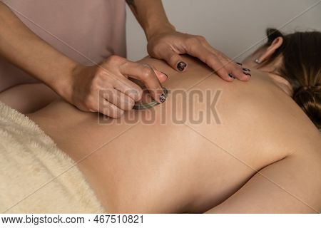 Massage Therapist At The Spa Does A Massage With A Vacuum Jar On The Back Of His Client For A Healin
