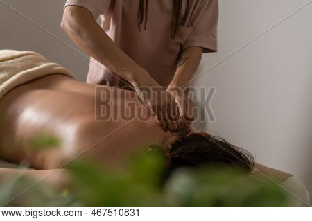 Close-up Of The Masseur's Hands Doing A Back Massage To A Woman In The Salon In A Cozy Atmosphere. C