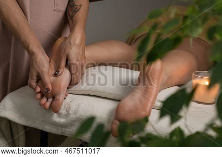 Masseur Gives A Foot Massage To A Young Woman In A Spa Salon In A Pleasant Atmosphere. Concept Of He