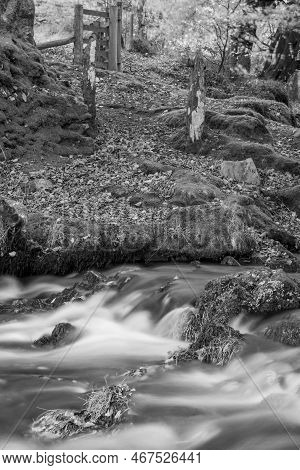 Long Exposure Of The Weir Water River Flowing Downstream Of Robbers Bridge In Exmoor National Park