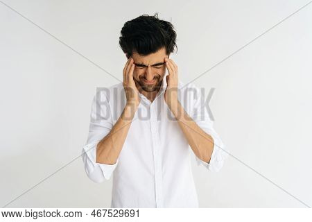 Studio Portrait Of Frustrated Young Man With Closed Eyes Massaging Temples Suffering From Headache P