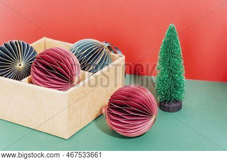 Christmas Paper Balls In A Box And Fir Tree Toy On Red And Green Background. New Year Concept. Close