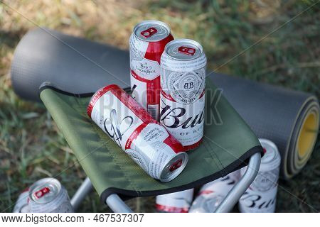 Sumy, Ukraine - August 01, 2021: Few Cans Of Budweiser Lager Alcohol Beer On Fisherman Chair Outdoor