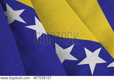 Bosnia And Herzegovina Flag With Big Folds Waving Close Up Under The Studio Light Indoors. The Offic