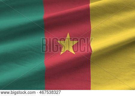 Cameroon Flag With Big Folds Waving Close Up Under The Studio Light Indoors. The Official Symbols An