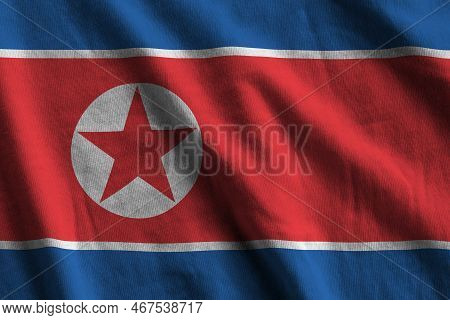 North Korea Flag With Big Folds Waving Close Up Under The Studio Light Indoors. The Official Symbols
