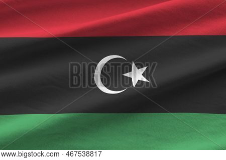 Libya Flag With Big Folds Waving Close Up Under The Studio Light Indoors. The Official Symbols And C