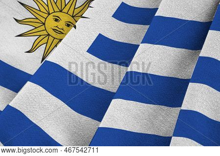 Uruguay Flag With Big Folds Waving Close Up Under The Studio Light Indoors. The Official Symbols And