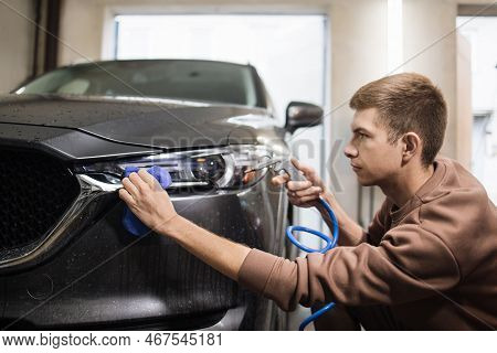 Car Wash And Cleaning At Professional Auto Service Station. Close Up View Of Caucasian Young Male Wo
