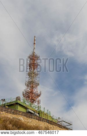 Communications Tower Under Cloudy Sky.