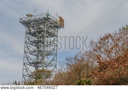 Communications Tower Under Cloudy Sky.