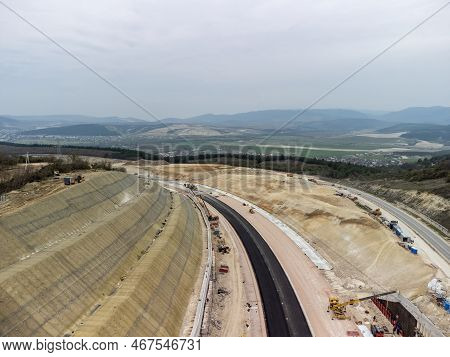 Mountain Road Constraction. Workers Reinforce The Slope Over The New Road. Road Construction In Prog