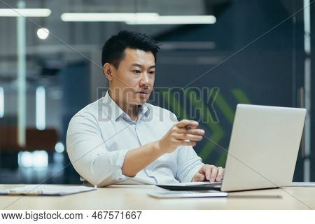 Business Online Meeting. A Young Asian Serious Businessman Holds A Meeting With Partners, Clients, A