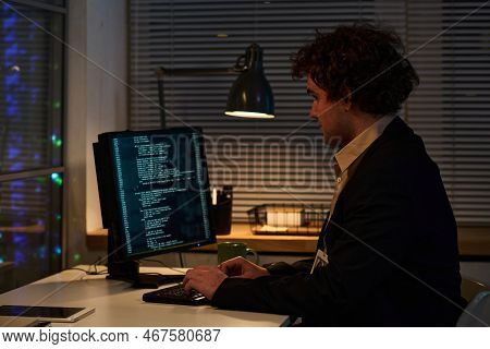 Young Programmer Concentrating On His Work With Codes On Computer Sitting At His Workplace In Office