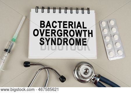 Medical Concept. On A Gray Surface, A Syringe, A Thermometer, A Stethoscope, A Blister And A Notepad