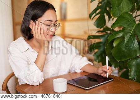 Young Artist Drawing On Digital Tablet, Using Graphic Pen, Drinking Coffee In Cafe And Scatching Smt