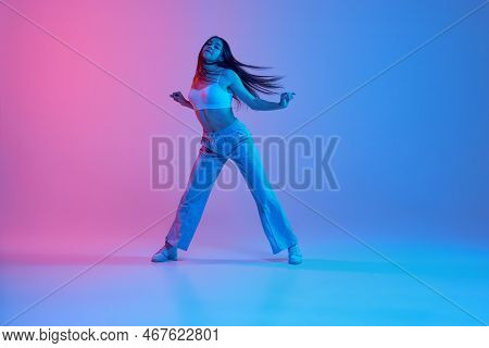 Young Sportive Girl Dancing, Training Over Gradient Pink Blue Background In Neon Light. Hip-hop