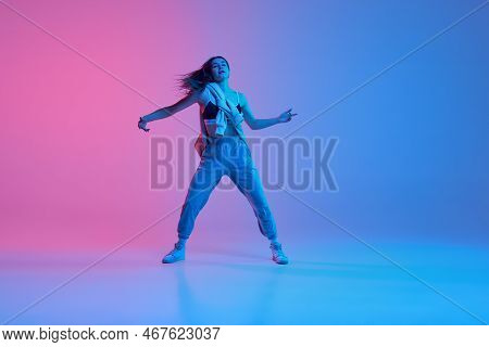 Young Girl Dancing Hip-hop, Contemp Over Gradient Pink Blue Background In Neon Light. Dance Club