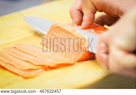 Close Up. Professional Chef Slicing Thin Slices Of Salmon