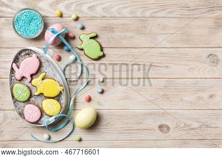 Colorful Easter Cookies In Basket With Multi Colors Easter Eggs On Colored Background . Pastel Color