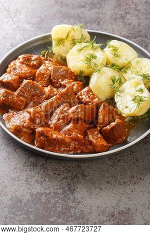 Vienna Goulash Or Wiener Saftgulasch Served With Boiled Potatoes Closeup On The Plate On The Table. 