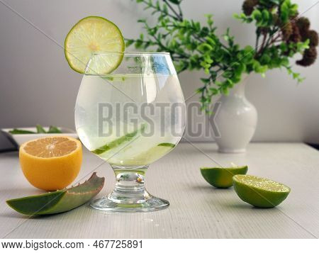 Detox Water Of Aloe Vera And Lemon Juice. A Glass Of Healthy Drink And Slices Of Lime And Sabila On 