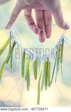 Close Up Lady Holding Necklace With Grass And White Gems Concept Photo. First View Hand Photography 