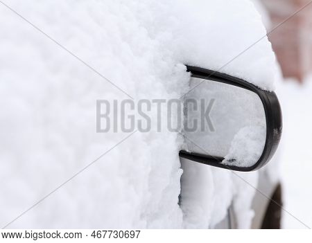 Only Side Mirror Of Car Is Visible From Under The Snow. A Parked Passenger Car Was Covered With Snow