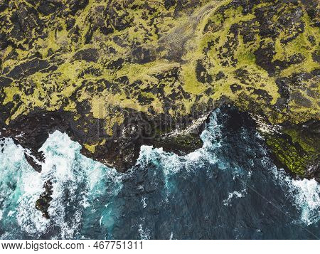 Top Down View At A Cliff And Waves Crushing On The Rocky Volcanic Coast On Stormy Autumn Day
