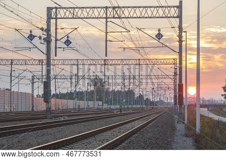 Railroad Tracks And Overhead Power Supply Catenary At Sunset