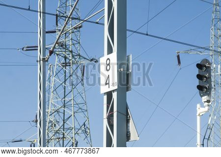 Rail Signal, Catenary Overhead Line, Power Transmission Line Tower Sunlit Against Blue Sky
