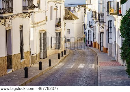 Typical Street Of Andalusian Village With Its Houses Painted White And Windows With Iron Bars, Medin