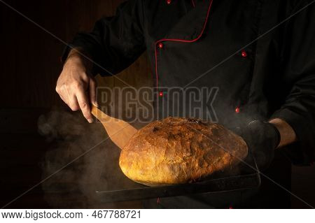 The Baker Bakes Bread On A Sheet Pan In A Bakery. Scraper In The Chef Hand. Place For Menu Or Recipe