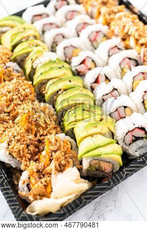 Pre-packaged Variety Of Sushi And Sushi Rolls In A Plastic Tray.