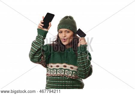 Happy Pleasant Multi-ethnic In Green Woolen Clothes, Smiling A Toothy Smile, Dancing With Credit Car