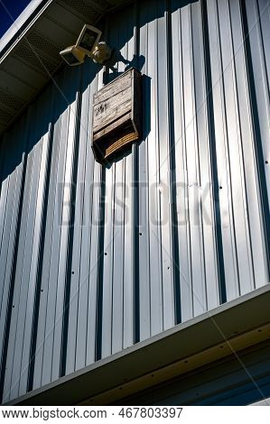 Wooden Bat House On White Corrugated Tin Barn