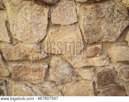 Close Up. A Fragment Of An Old Wall Made Of Natural Stone