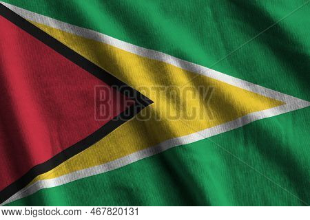 Guyana Flag With Big Folds Waving Close Up Under The Studio Light Indoors. The Official Symbols And 