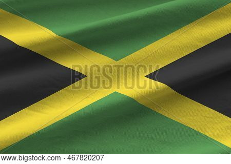 Jamaica Flag With Big Folds Waving Close Up Under The Studio Light Indoors. The Official Symbols And