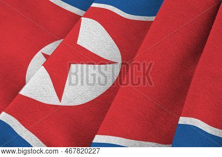 North Korea Flag With Big Folds Waving Close Up Under The Studio Light Indoors. The Official Symbols