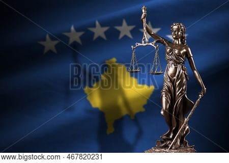 Kosovo Flag With Statue Of Lady Justice And Judicial Scales In Dark Room. Concept Of Judgement And P