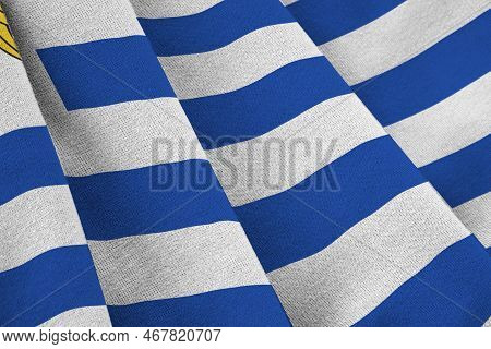 Uruguay Flag With Big Folds Waving Close Up Under The Studio Light Indoors. The Official Symbols And