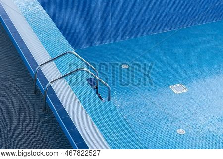 Descent To A Large Swimming Pool. Empty Swimming Pool With Descent Down. Staircase Leading To The Po